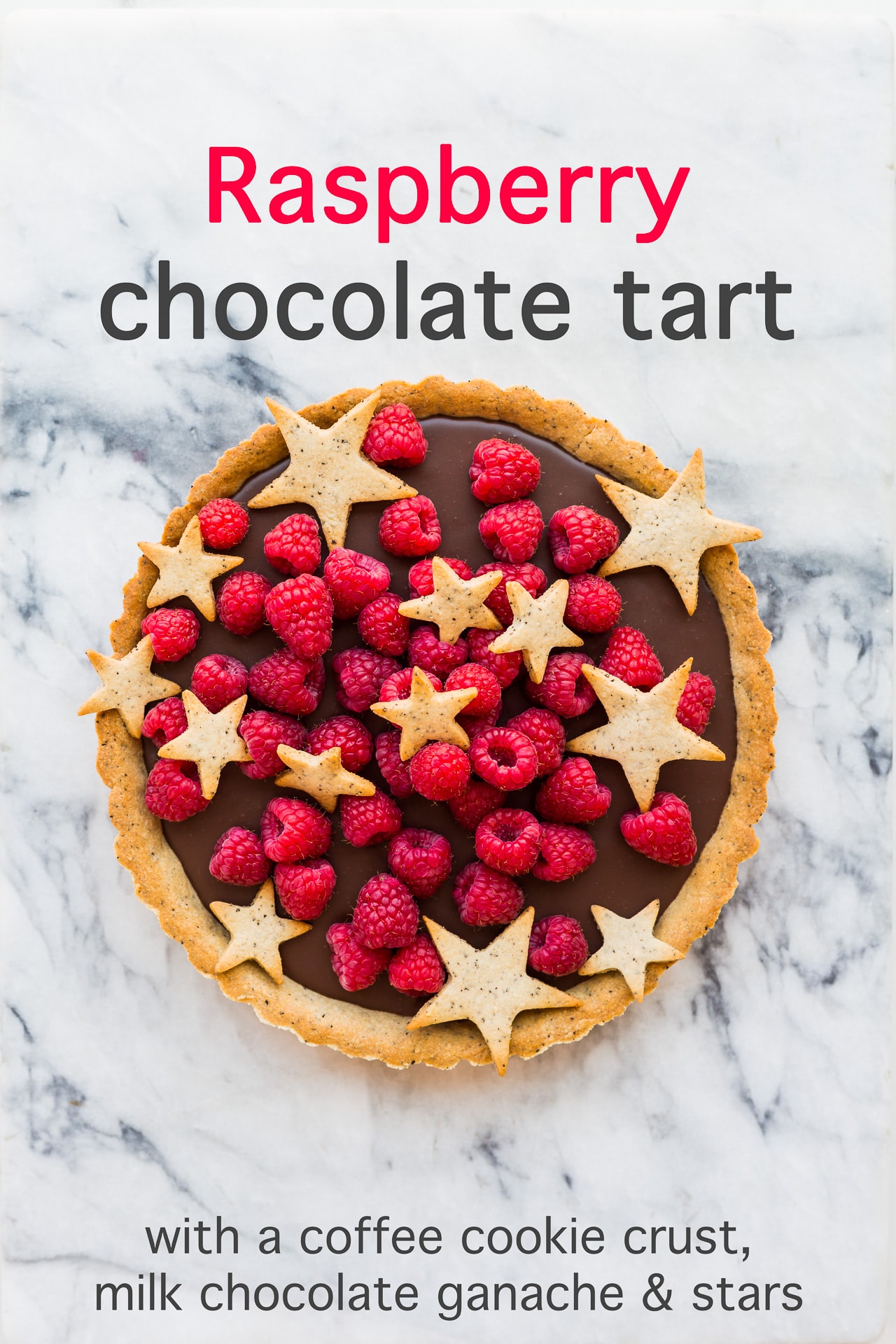 Raspberry chocolate tart with a milk chocolate ganache filling and a coffee cookie crust, decorated with fresh raspberries and star-shaped cookies