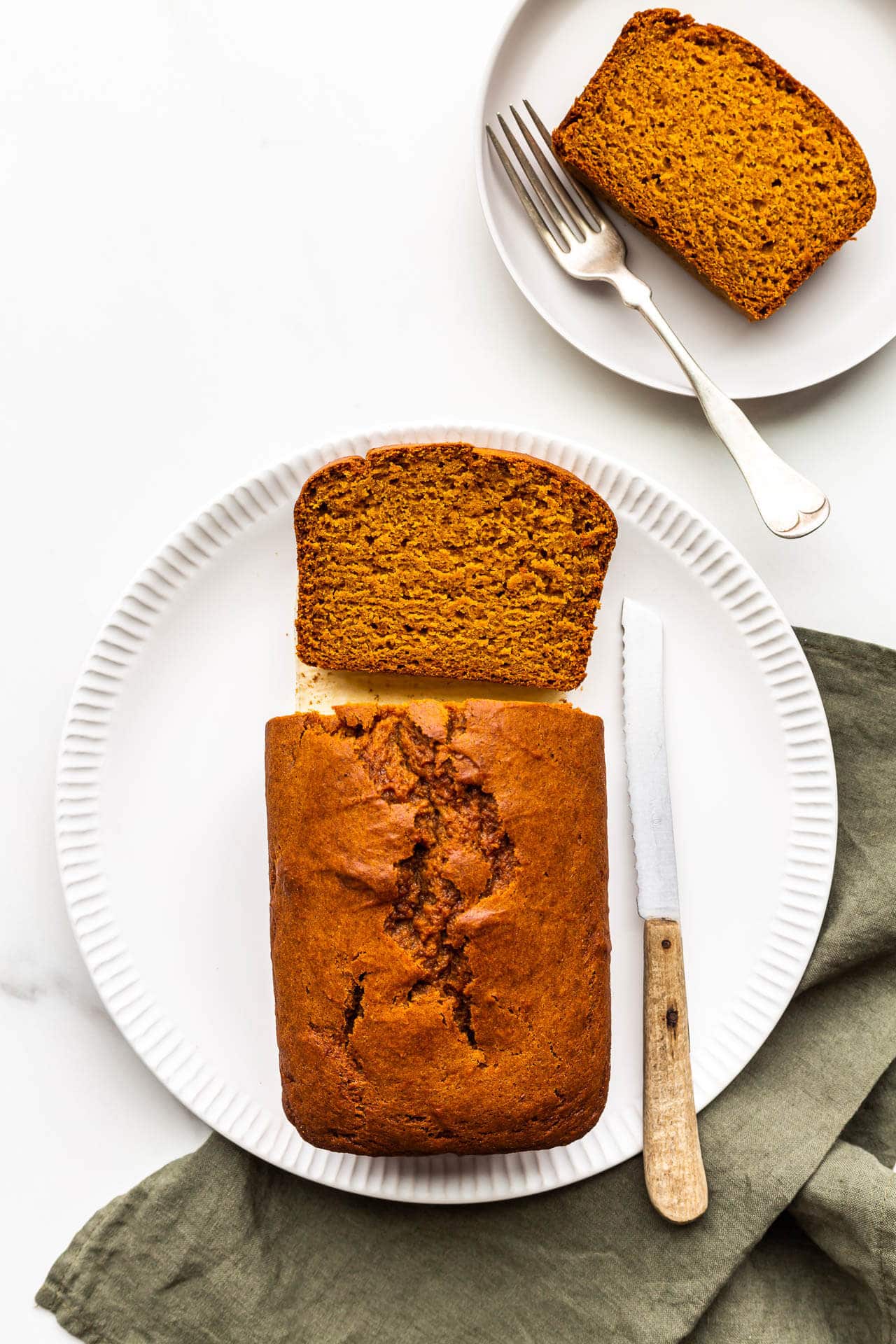 Slicing and serving a loaf of pumpkin bread.