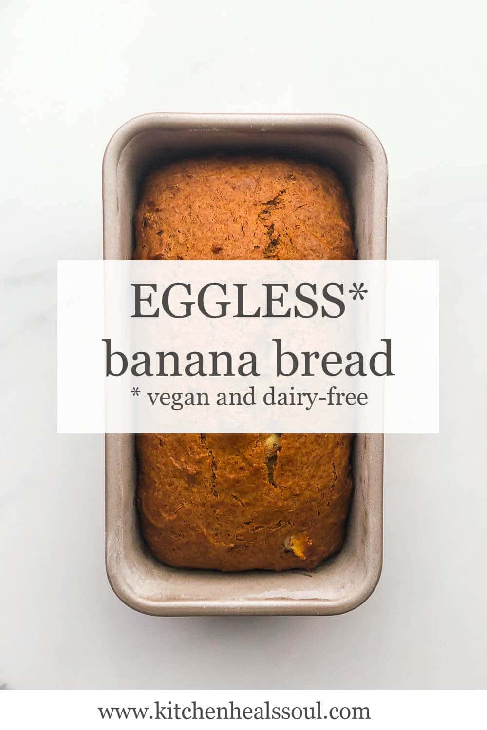 Loaf of eggless banana bread (vegan and dairy-free) in loaf pan on marble surface