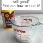 Testing baking powder by placing 1 teaspoon in ⅓ cup of hot water in a measuring cup to verify the mixture fizzes