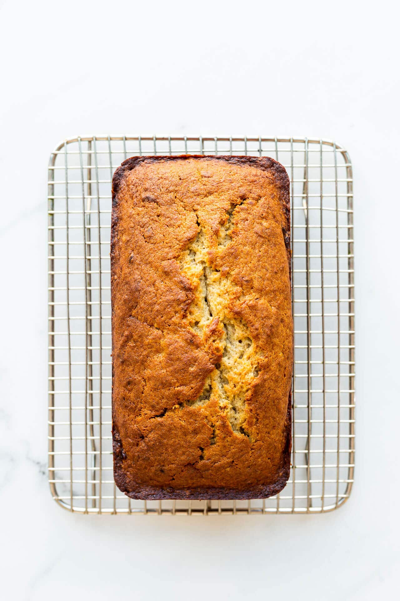 Golden brown banana bread on a vintage wire cooling rack