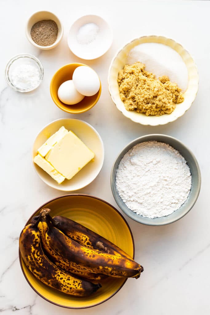 Basic banana bread ingredients: butter, sugar, eggs, bananas, flour, baking powder, and salt (cardamom for flavour).