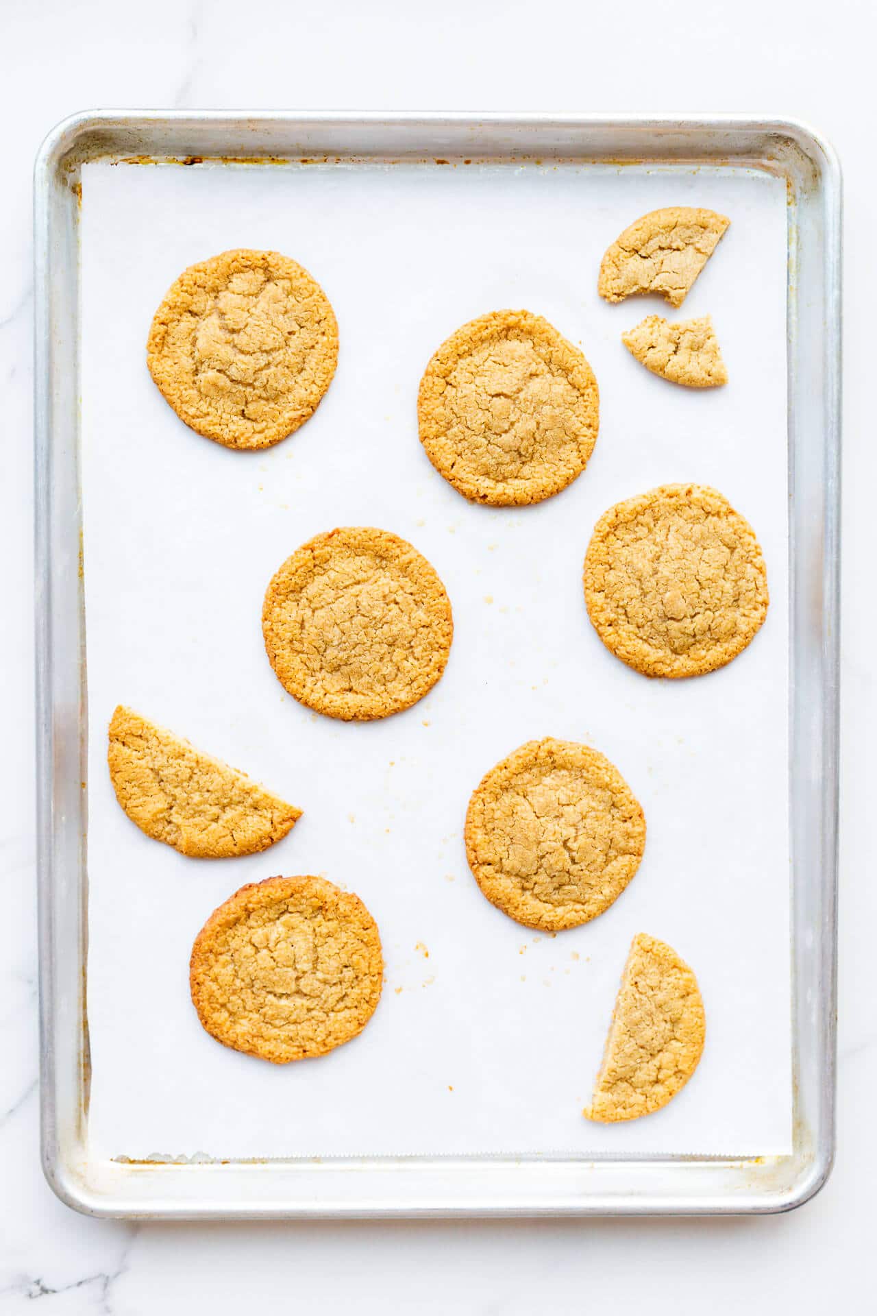 Flourless tahini cookies made with all natural tahini baked on a sheet lined with parchment papaer