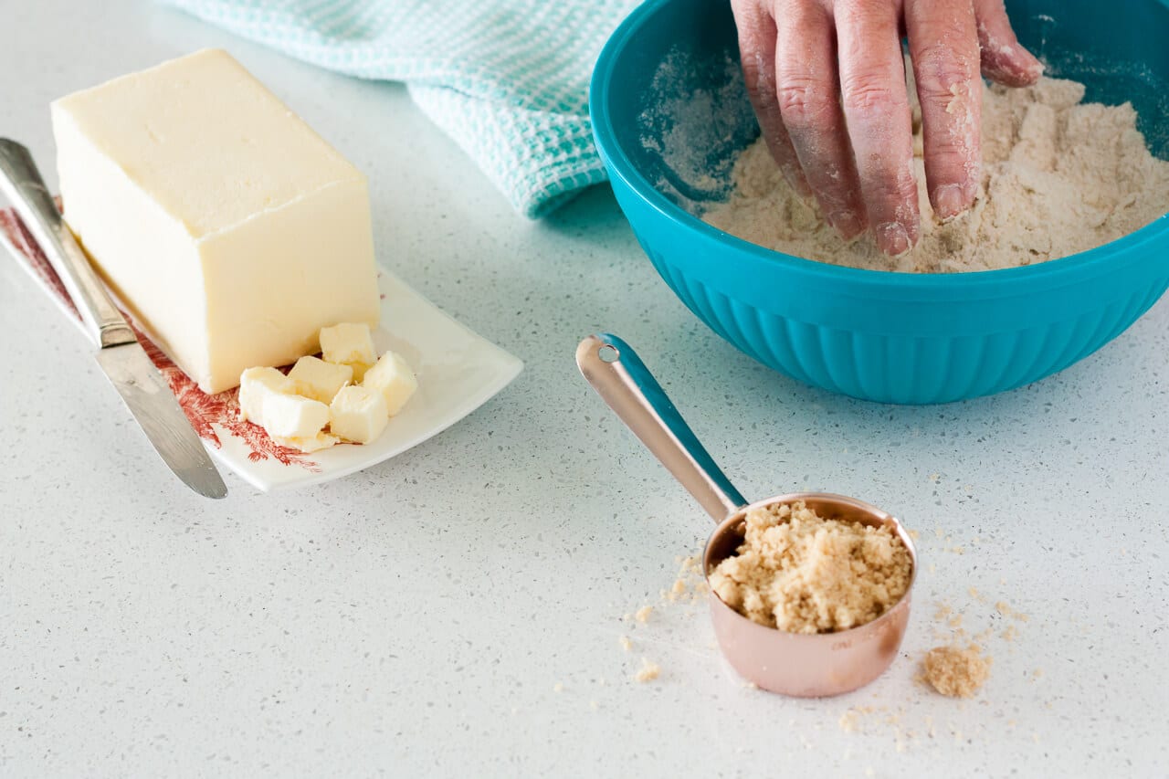 Making a crumble topping by hand with flour, butter, brown sugar