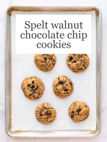 A sheet pan lined with parchment with baked thick chocolate chunk cookies (golden brown on the edges)