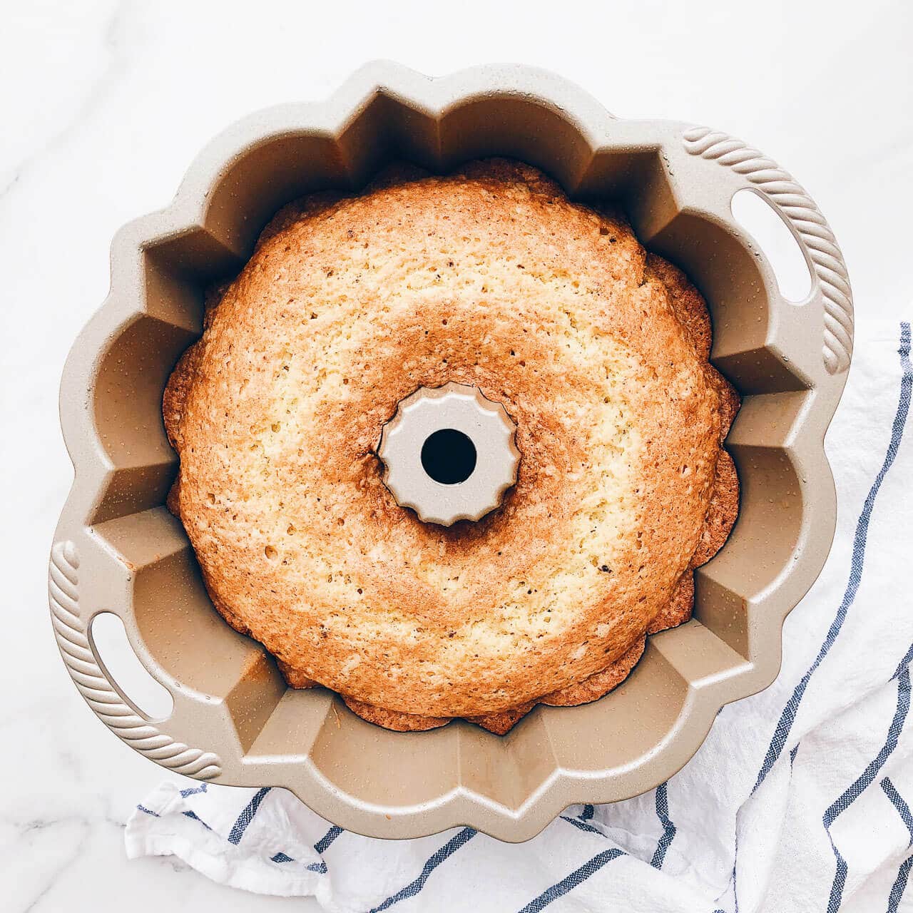 Freshly baked bundt cake baked in a classic bundt pan with handles