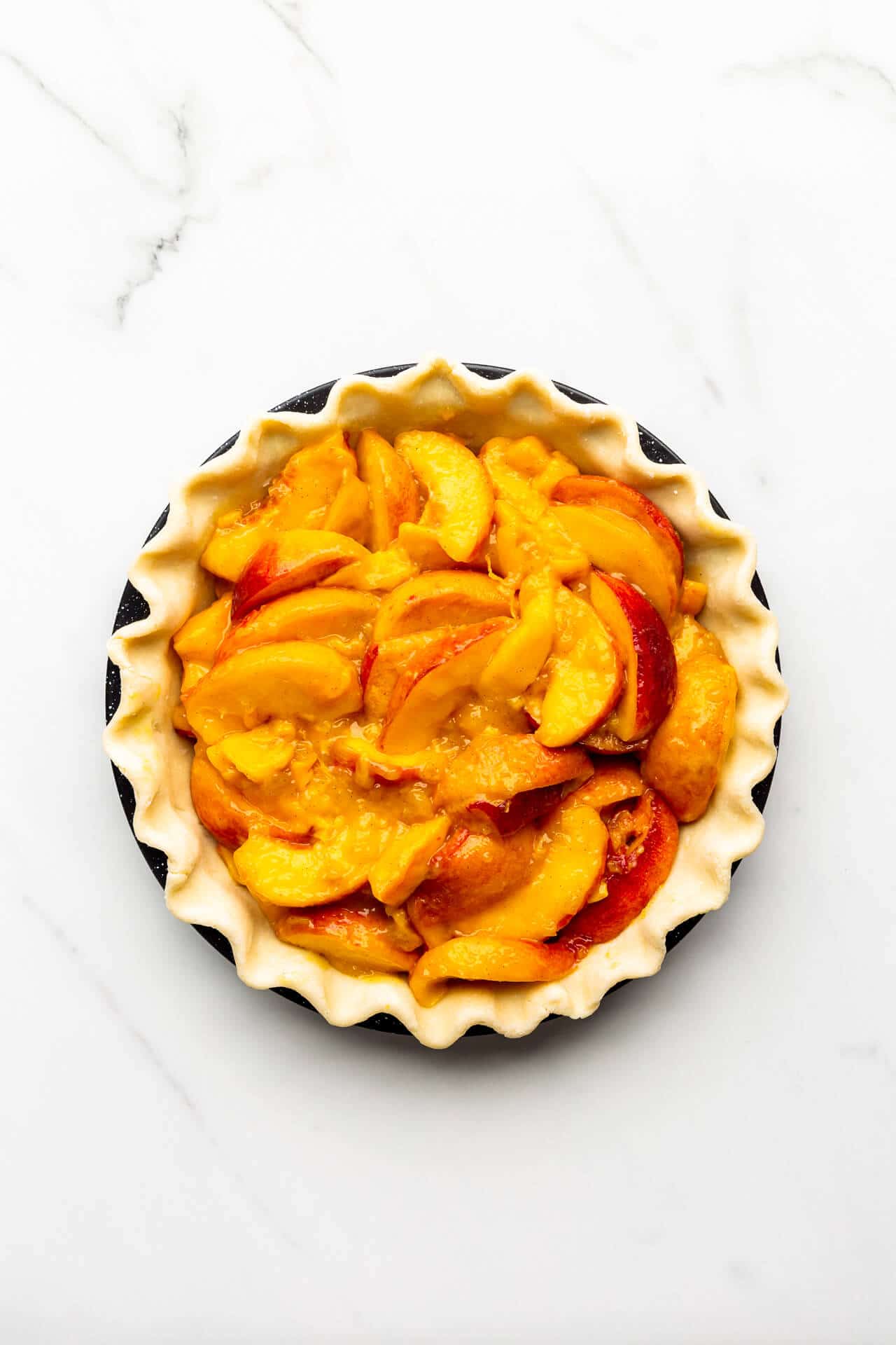 Filled peach mango pie ready for top crust
