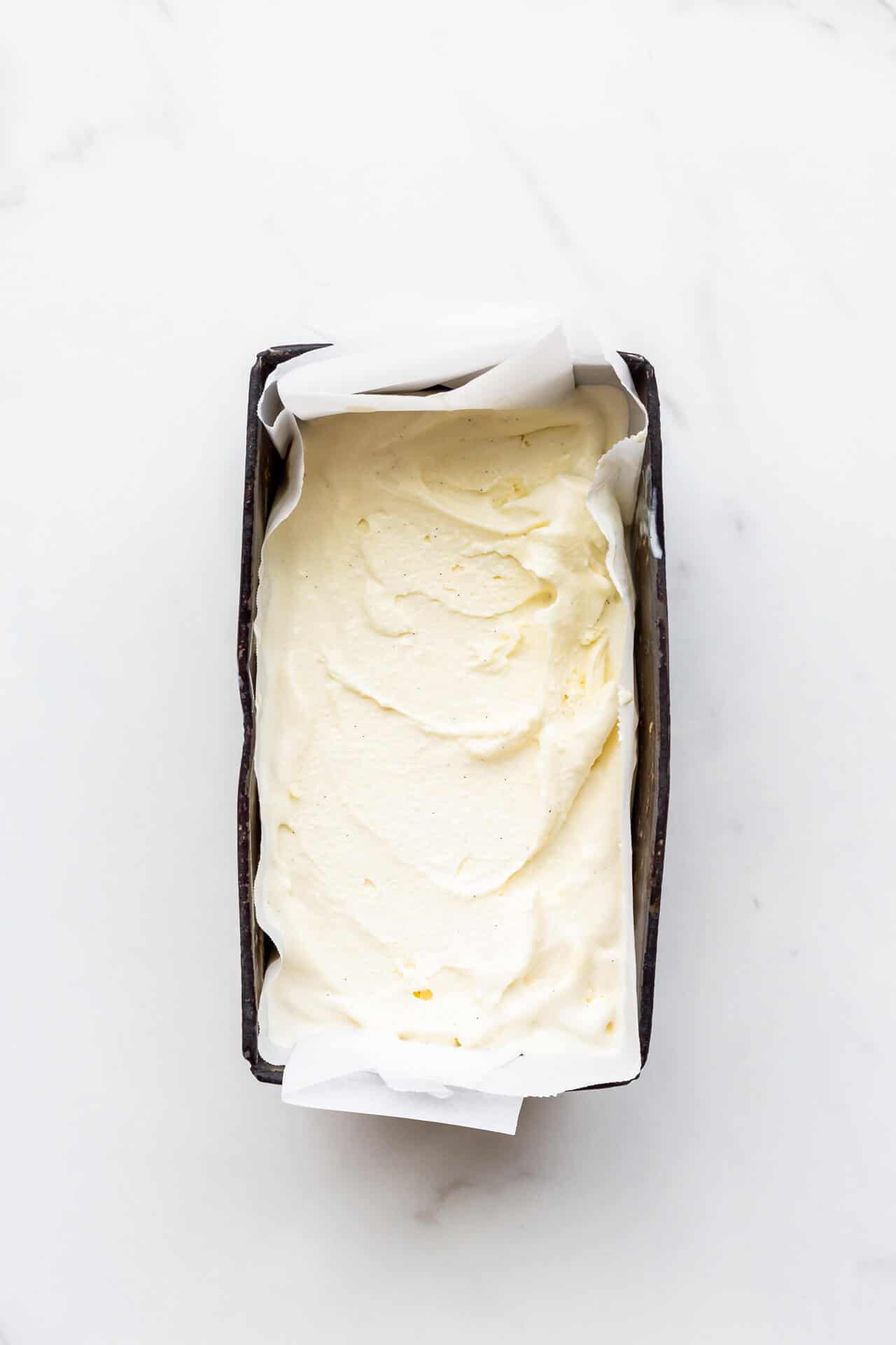 Freshly churned cardamom ice cream transfered to a big dark loaf pan to chill until frozen solid