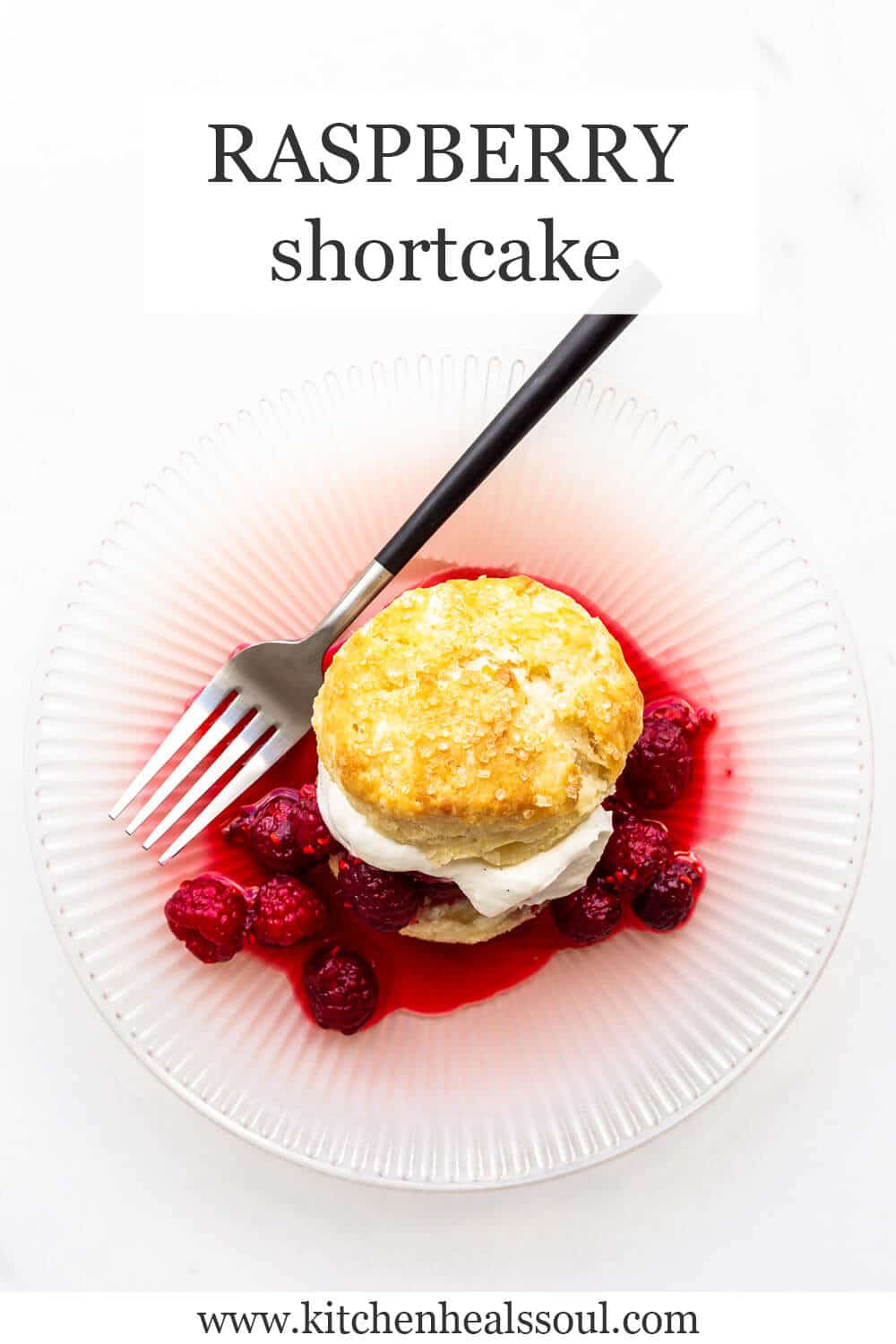 A raspberry shortcake on a pink plate with macerated raspberries and whipped cream served on a golden brown biscuit