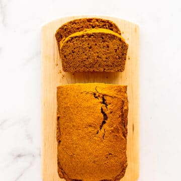 Sliced pumpkin bread on a wood cutting board