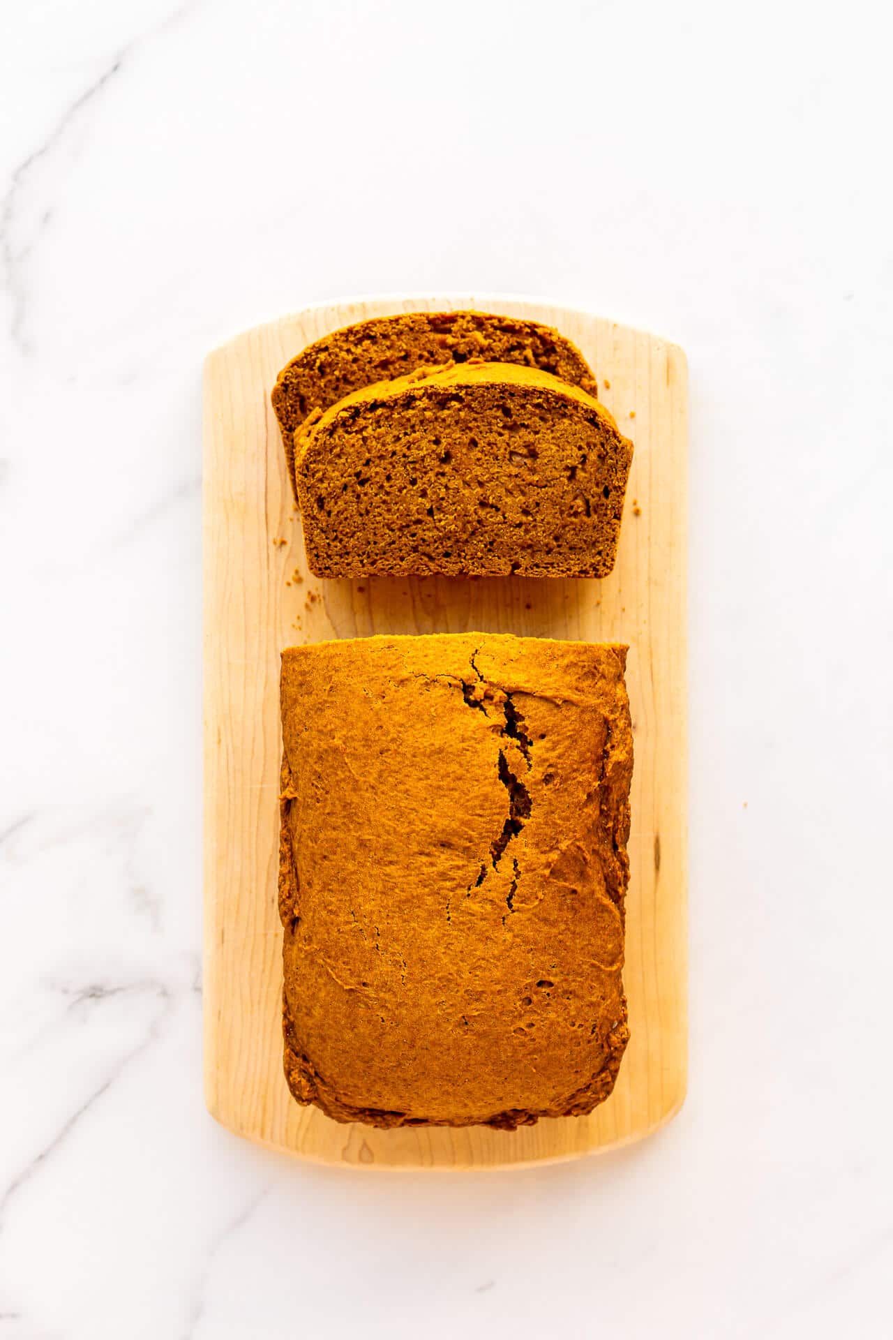 Sliced pumpkin bread on a wood cutting board