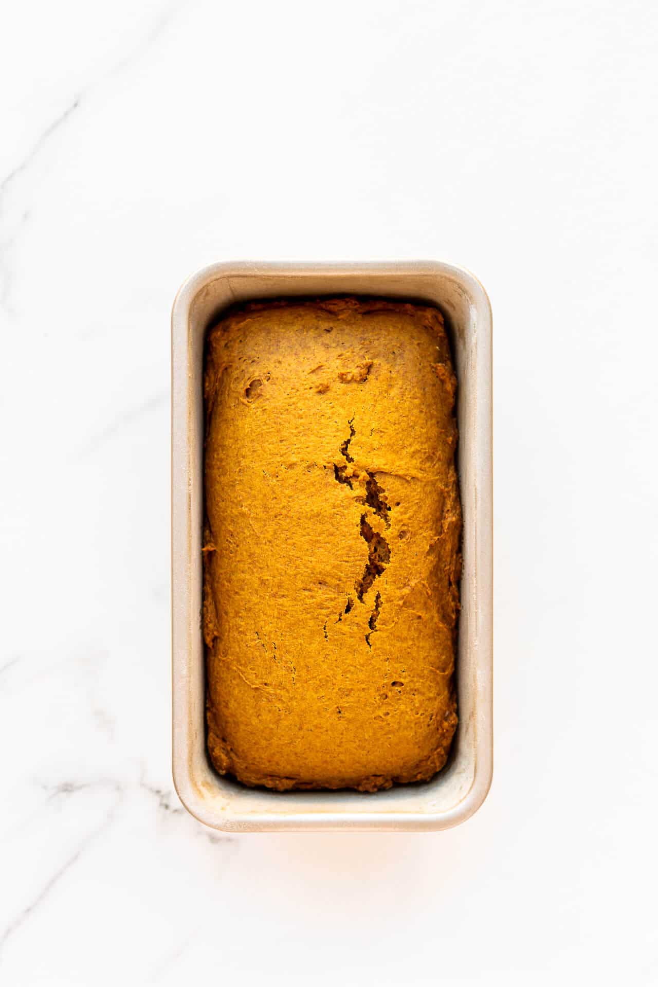 Freshly baked eggless pumpkin bread cooling in the loaf pan it was baked in