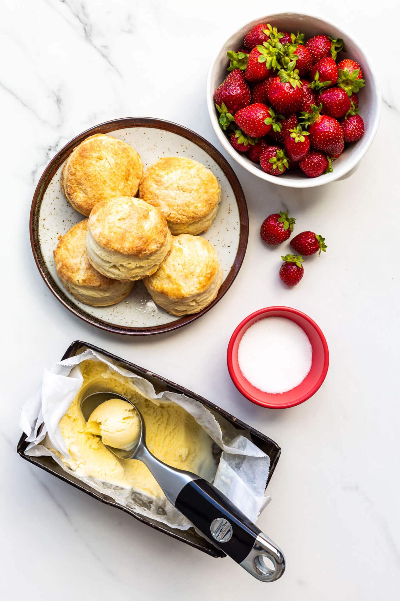 Components for making ice cream strawberries with biscuits and scoops of ice cream