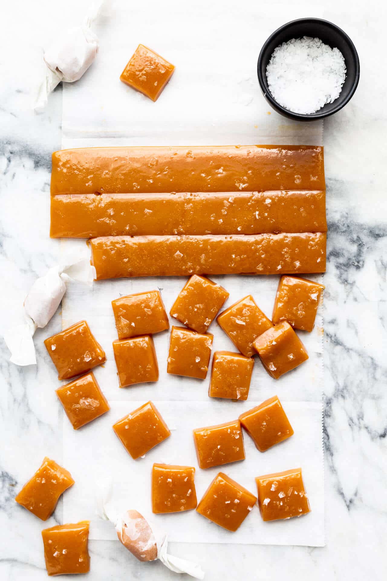 https://bakeschool.com/wp-content/uploads/2020/09/Cutting-salted-caramels-into-squares-and-wrapping-them.jpg