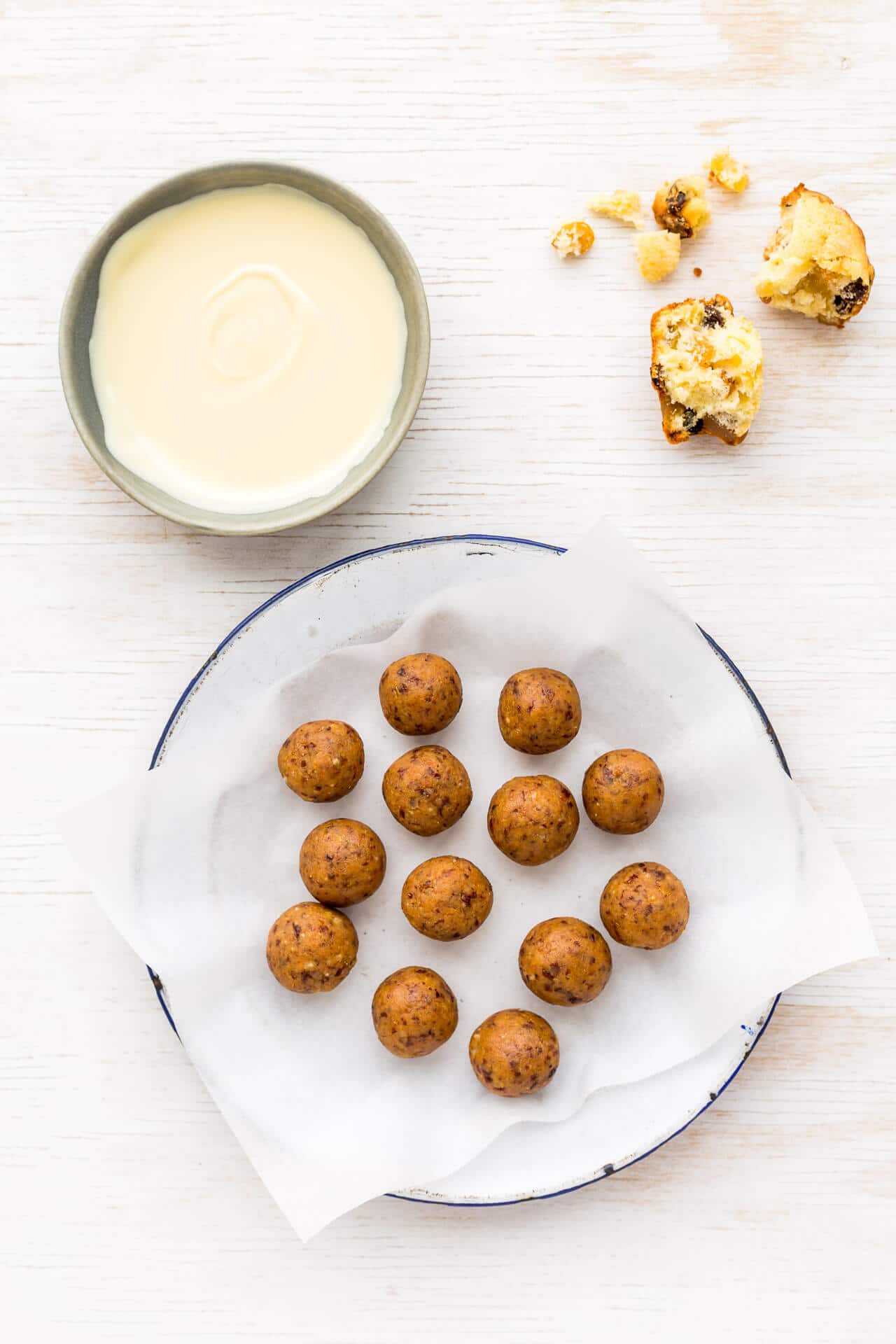 Fruitcake balls made from crumbled leftover fruitcake ready to be dipped in a bowl of melted white chocolate to coat them