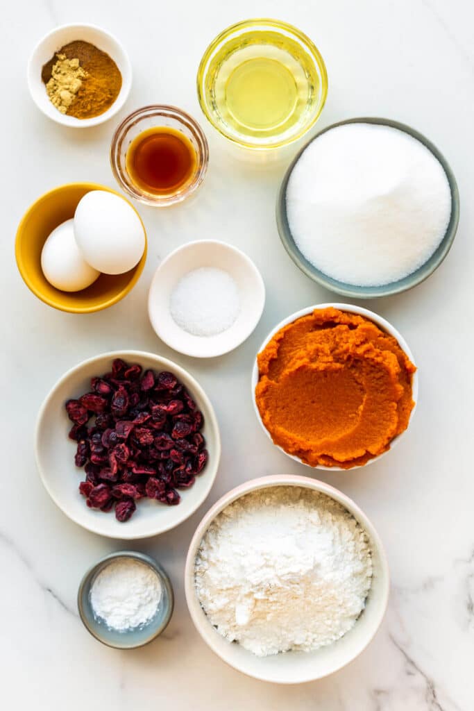 Ingredients to make pumpkin bread with dried cranberries measured out into little bowls