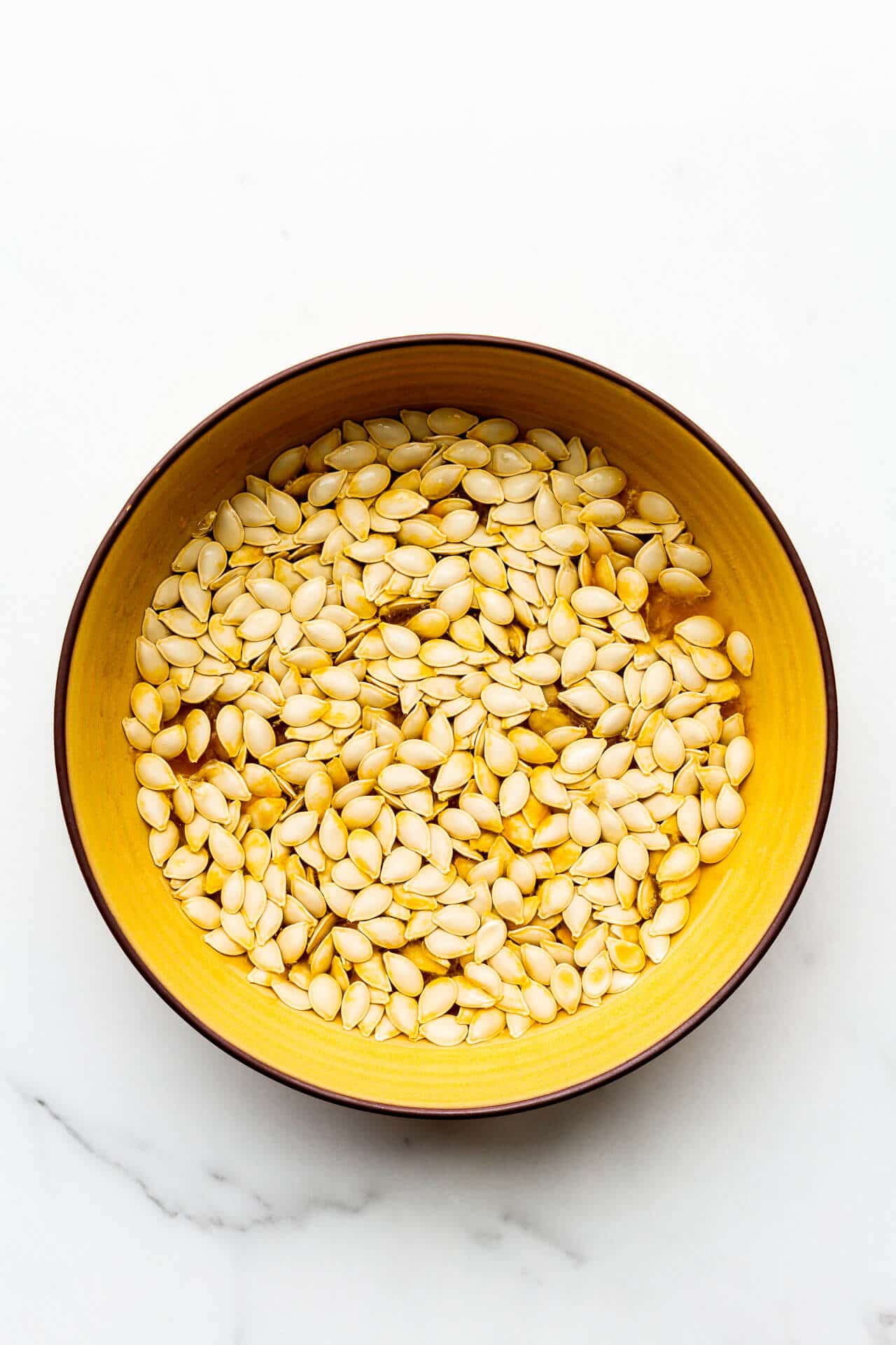 Soak pumpkin seeds in a bowl of water before baking.