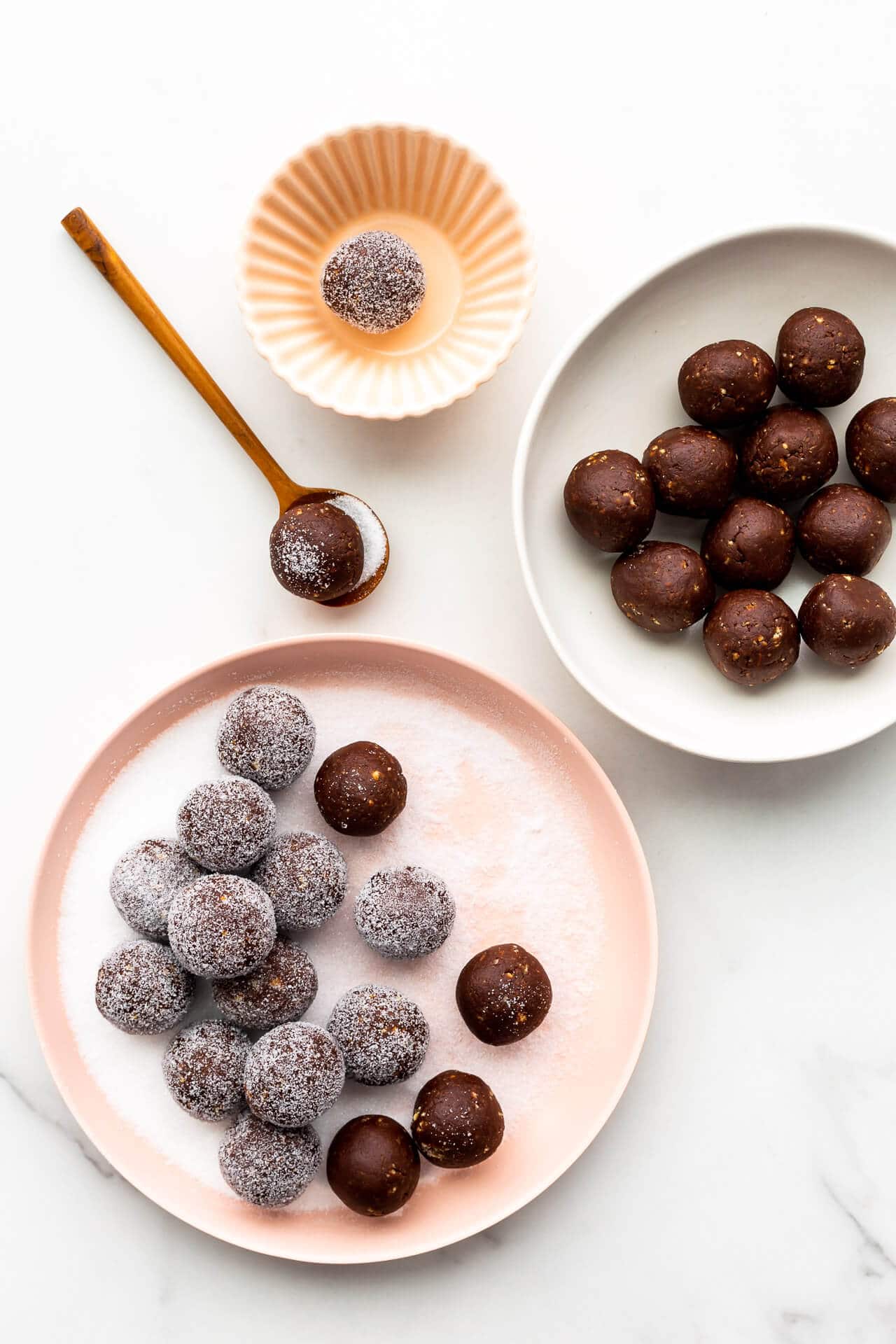 Coating amaretto balls in granulated sugar.