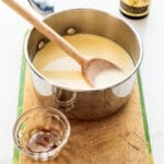 A saucepan of homemade crème anglaise (custard sauce) that is flavoured with vanilla bean paste.