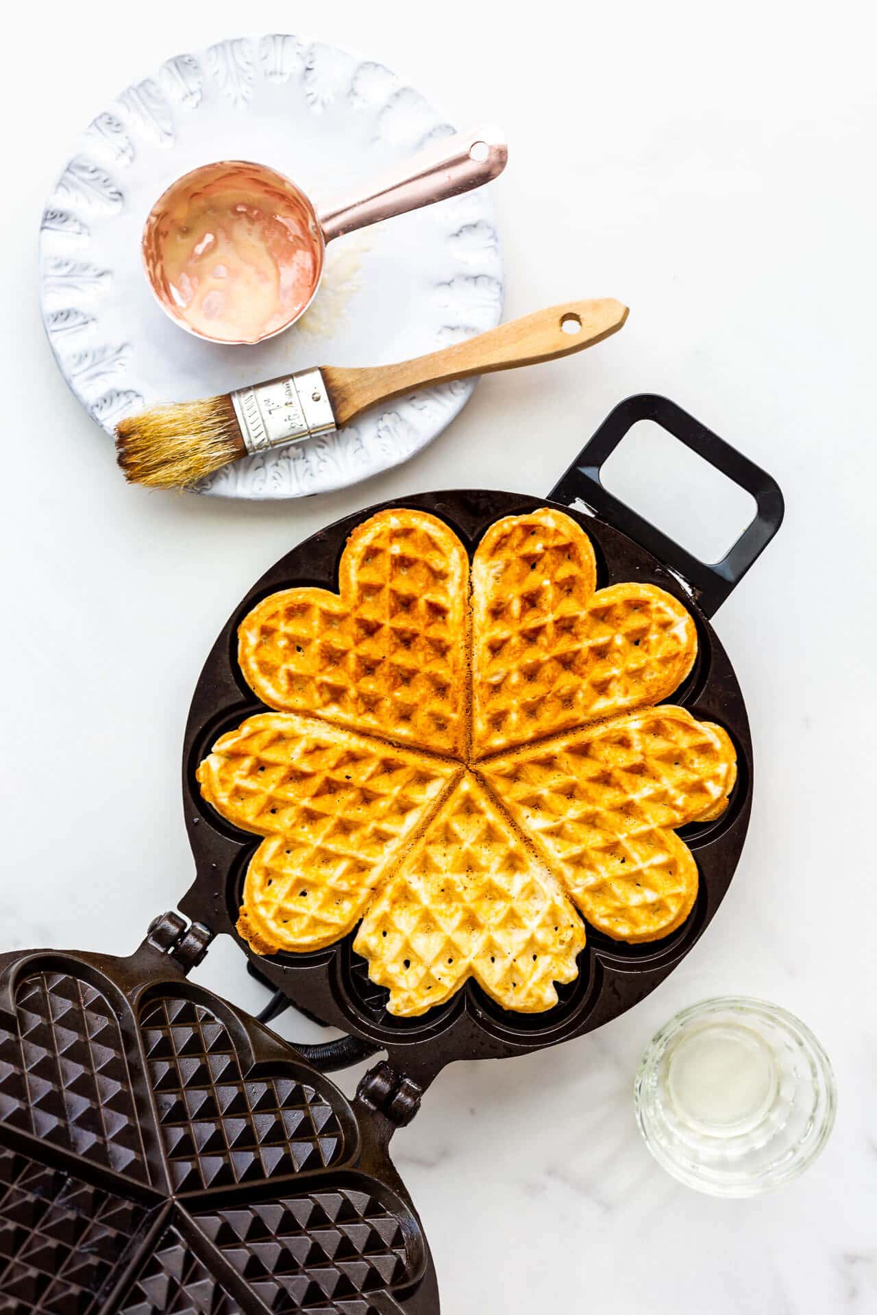Plain waffle being cooked in a waffle maker.