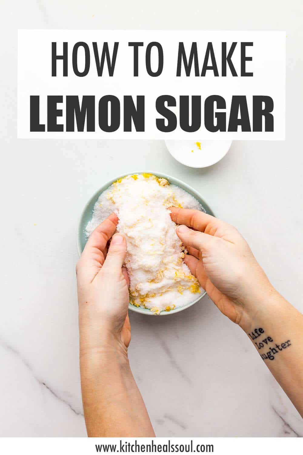 Making lemon sugar in a bowl by rubbing together granulated sugar and lemon zest with fingertips.