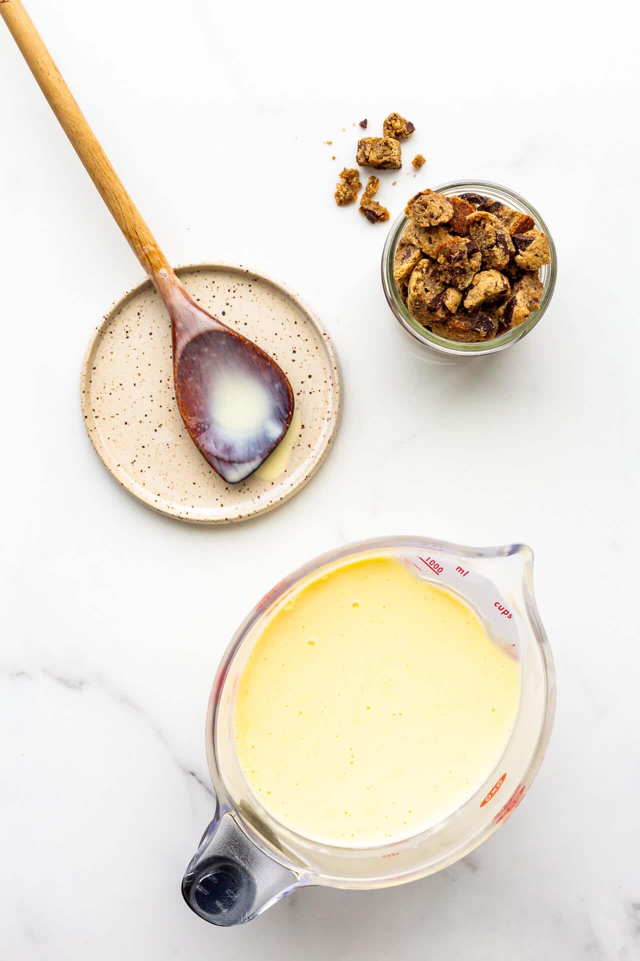 Crème anglaise custard base in a 4 cup measuring cup with a pouring spout, ready to be churned with chopped cookies to make cookie ice cream.