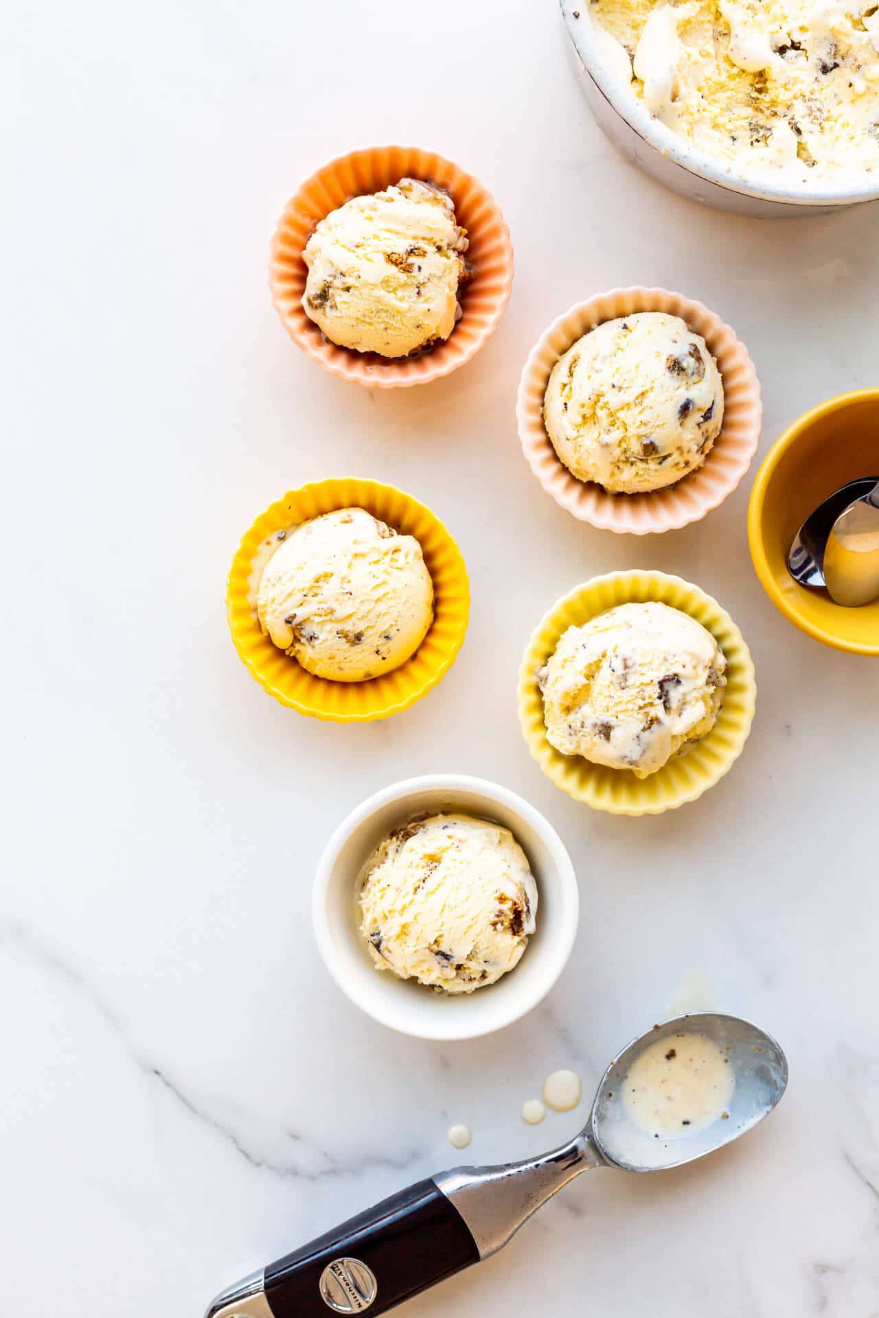 Chocolate chip ice cream scooped in pastel coloured bowls, ready to eat.