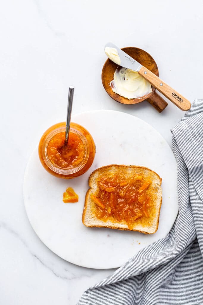 A piece of toast topped with orange marmalade.