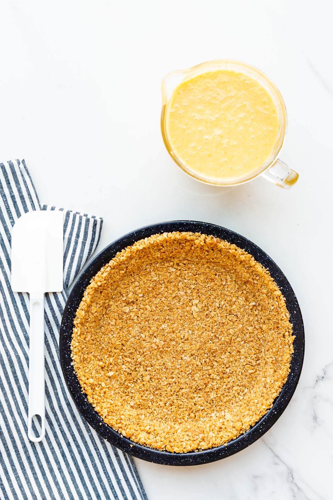 Oat cookie crumb crust ready to be filled with a custard filling to make the Milk Bar pie.