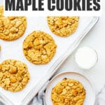 A sheet pan of freshly baked maple cookies with a glass of milk.