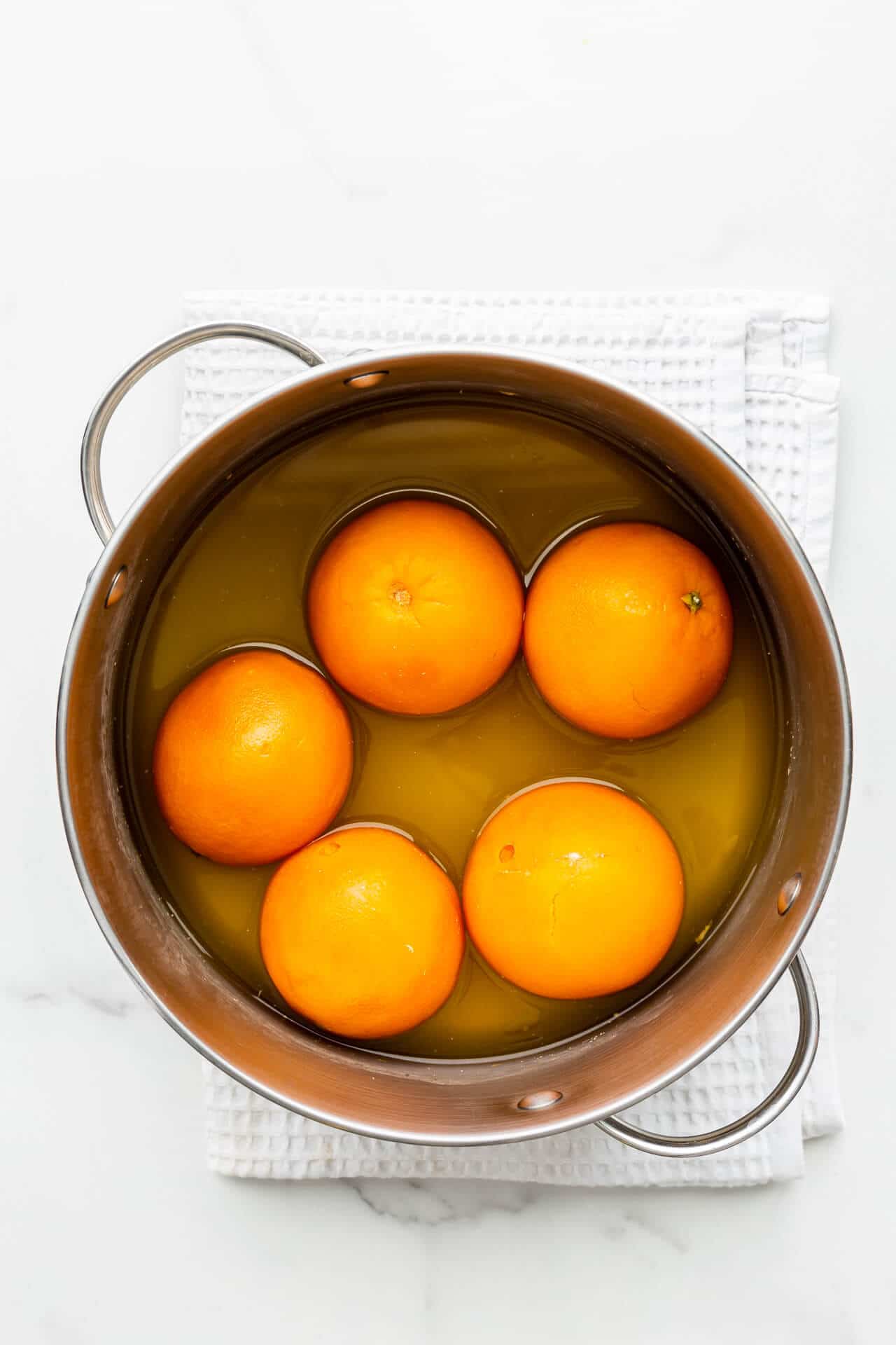 A pot of boiled oranges, ready to be sliced and transformed into orange marmalade.