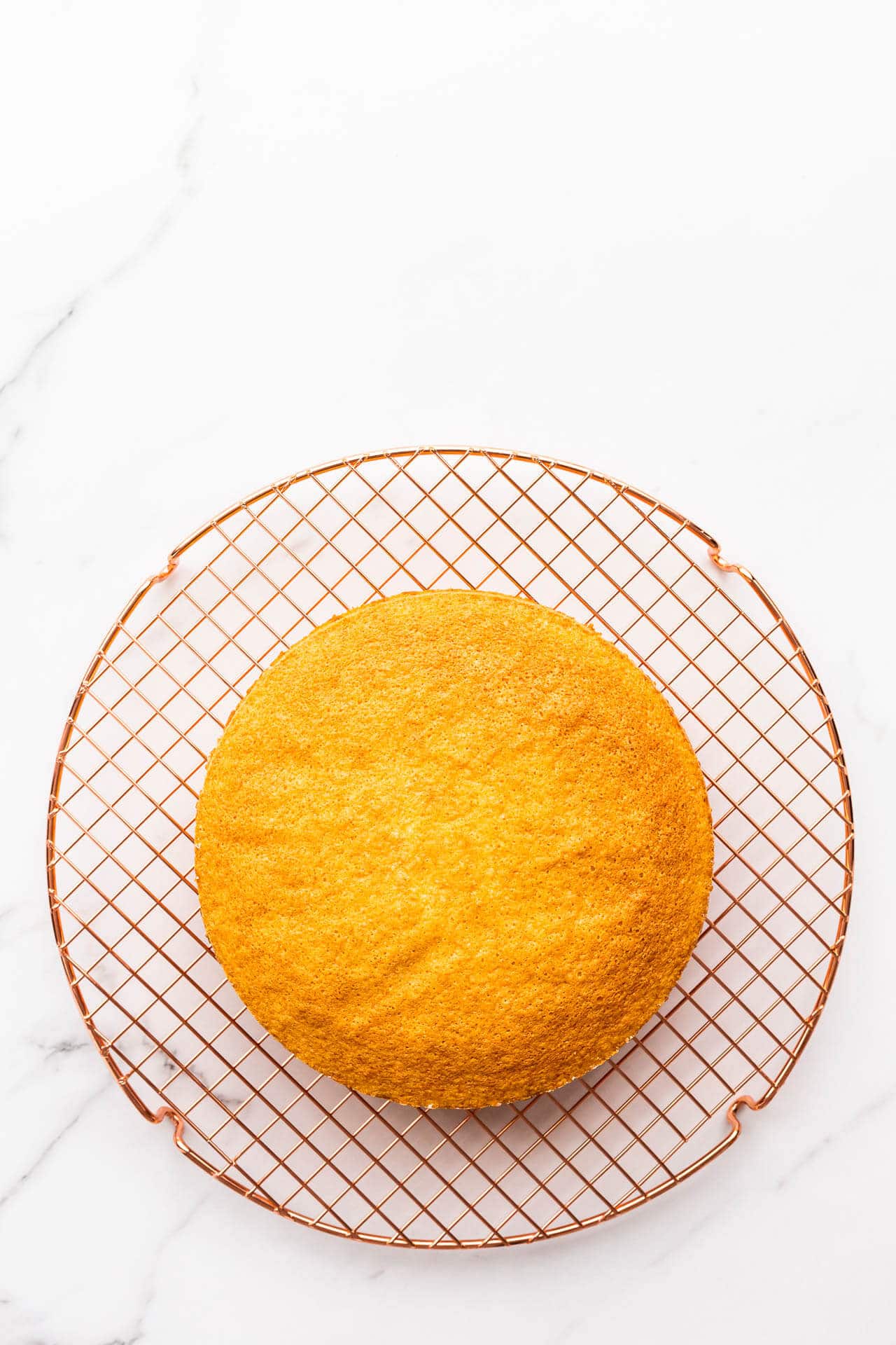 Sponge cake cooling on a wire rack.