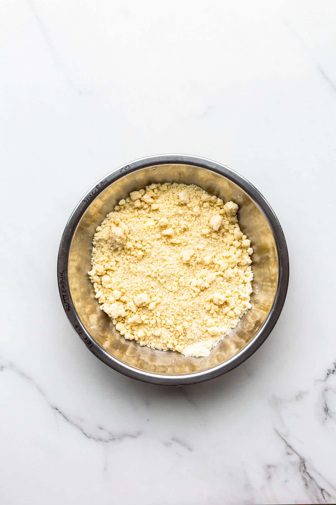 A bowl of homemade crumble topping ready to be sprinkled over fresh fruit to make a fruit crumble dessert.