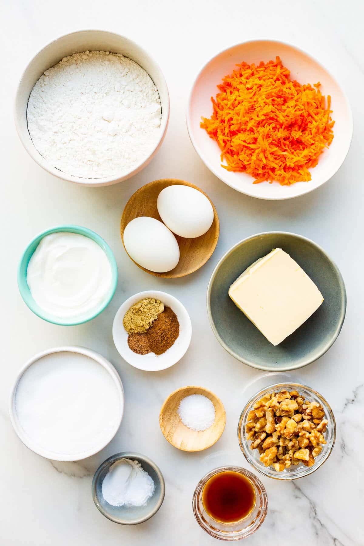 Ingredients measured out to make easy carrot muffins with walnuts and sour cream, ready to be mixed.