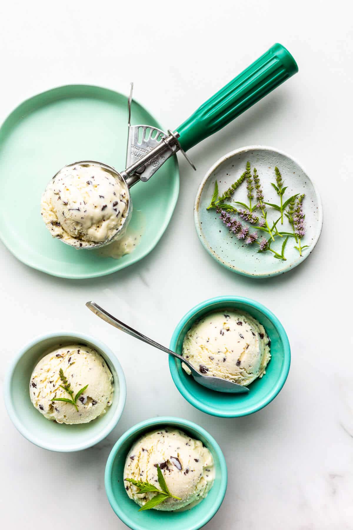 Green bowls with scoops of homemade mint chocolate chip ice cream.