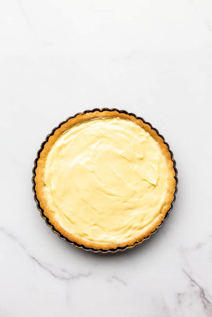 Baked tart shell filled with pastry cream.