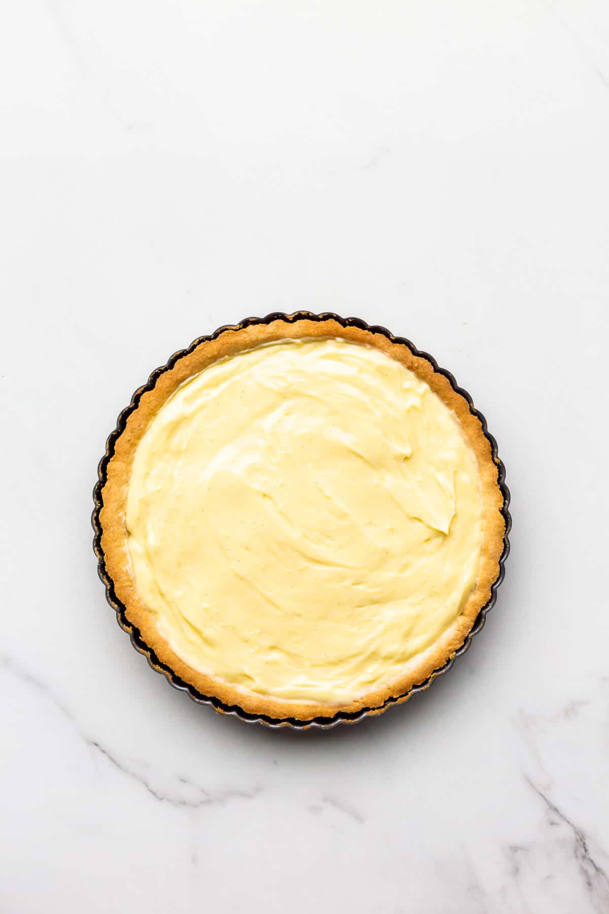 Baked tart shell filled with pastry cream.