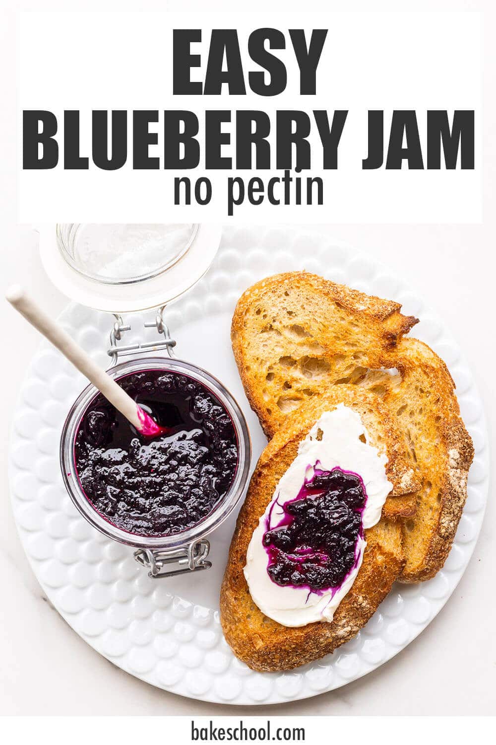 A jar of homemade blueberry jam served with cream cheese and toasted sourdough on a plate.