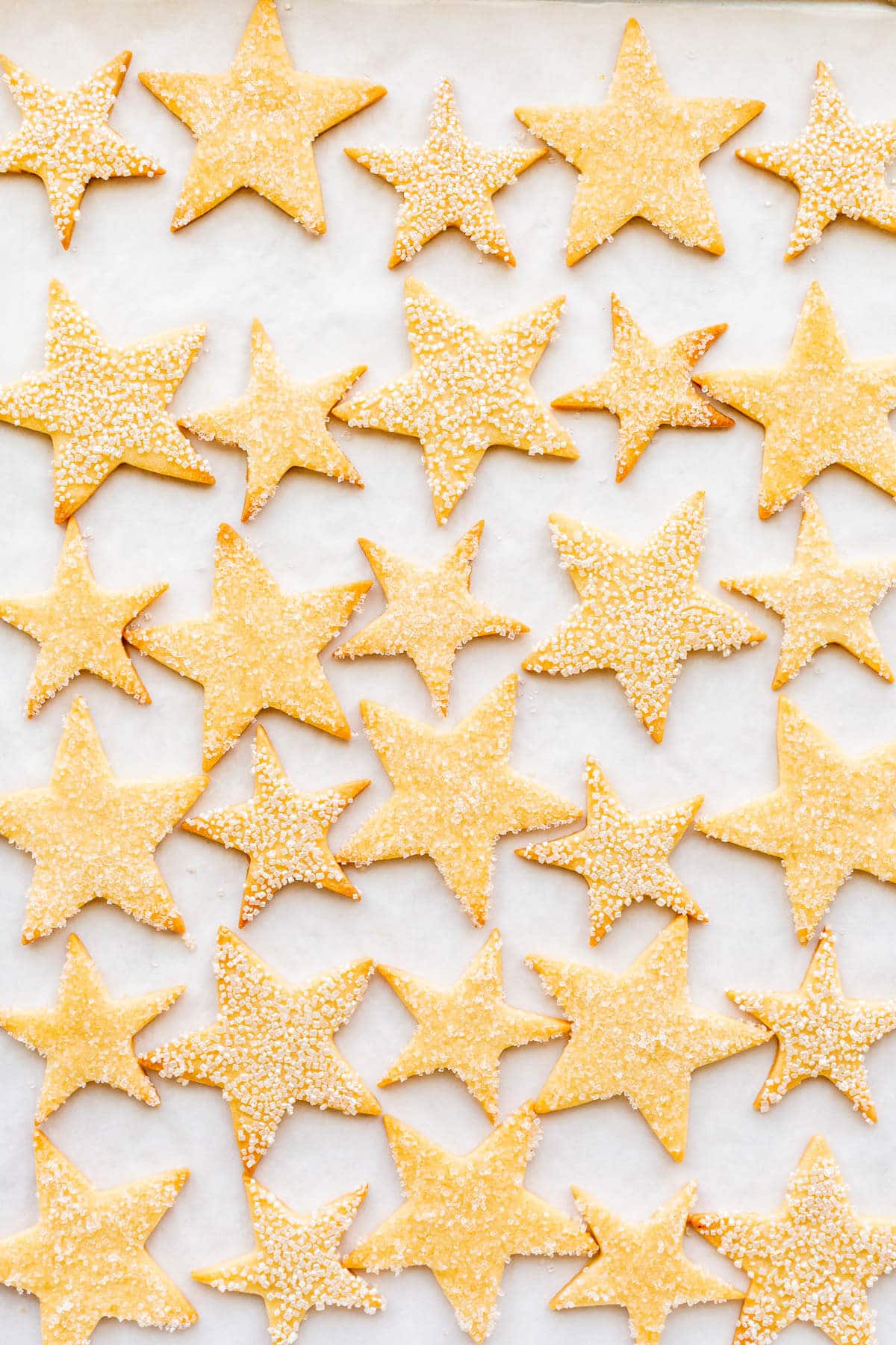 Rows and rows of sugar cookie stars coated in sanding sugar.