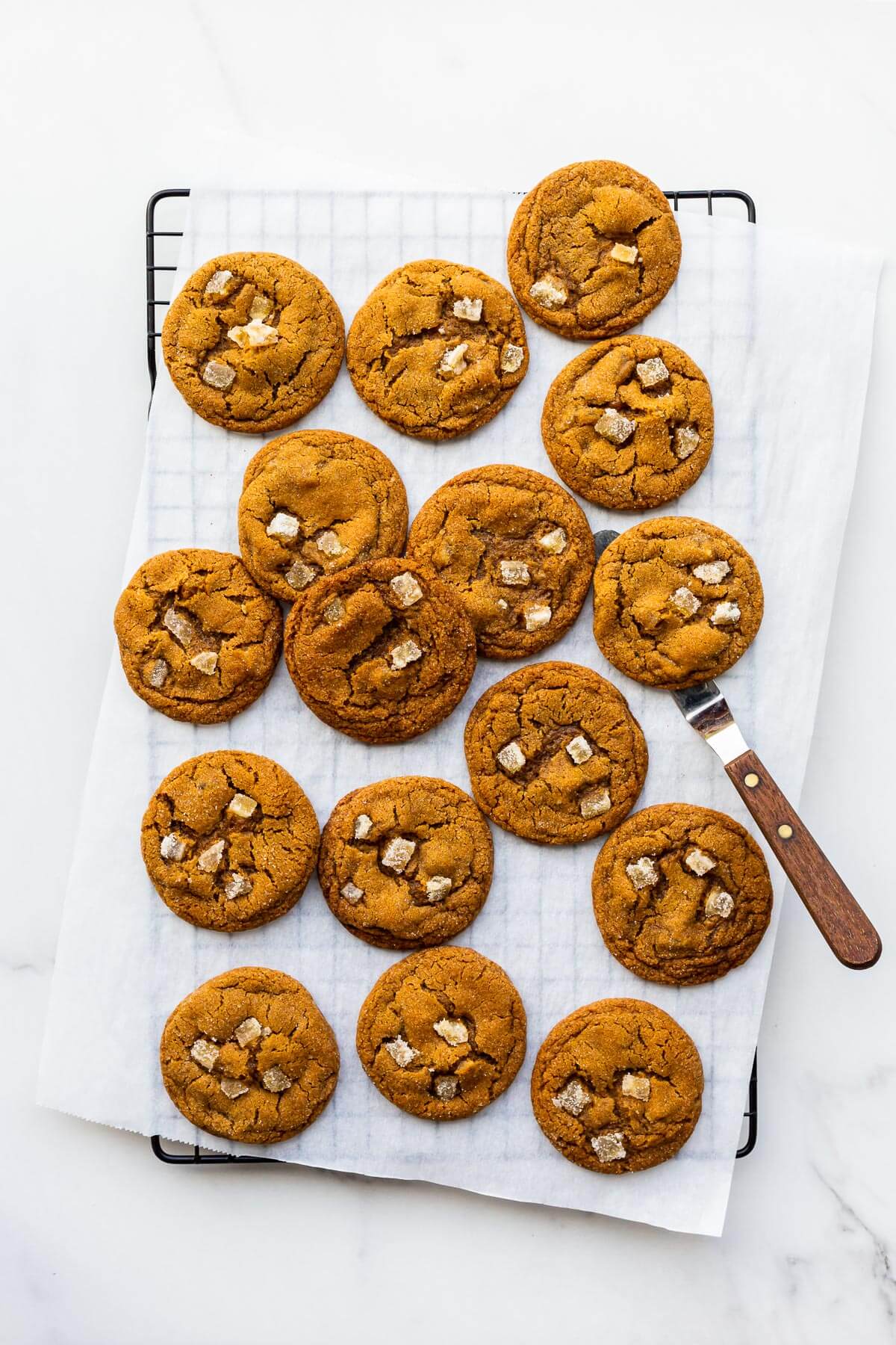 Freshly baked ginger cookies on a cooling rack.