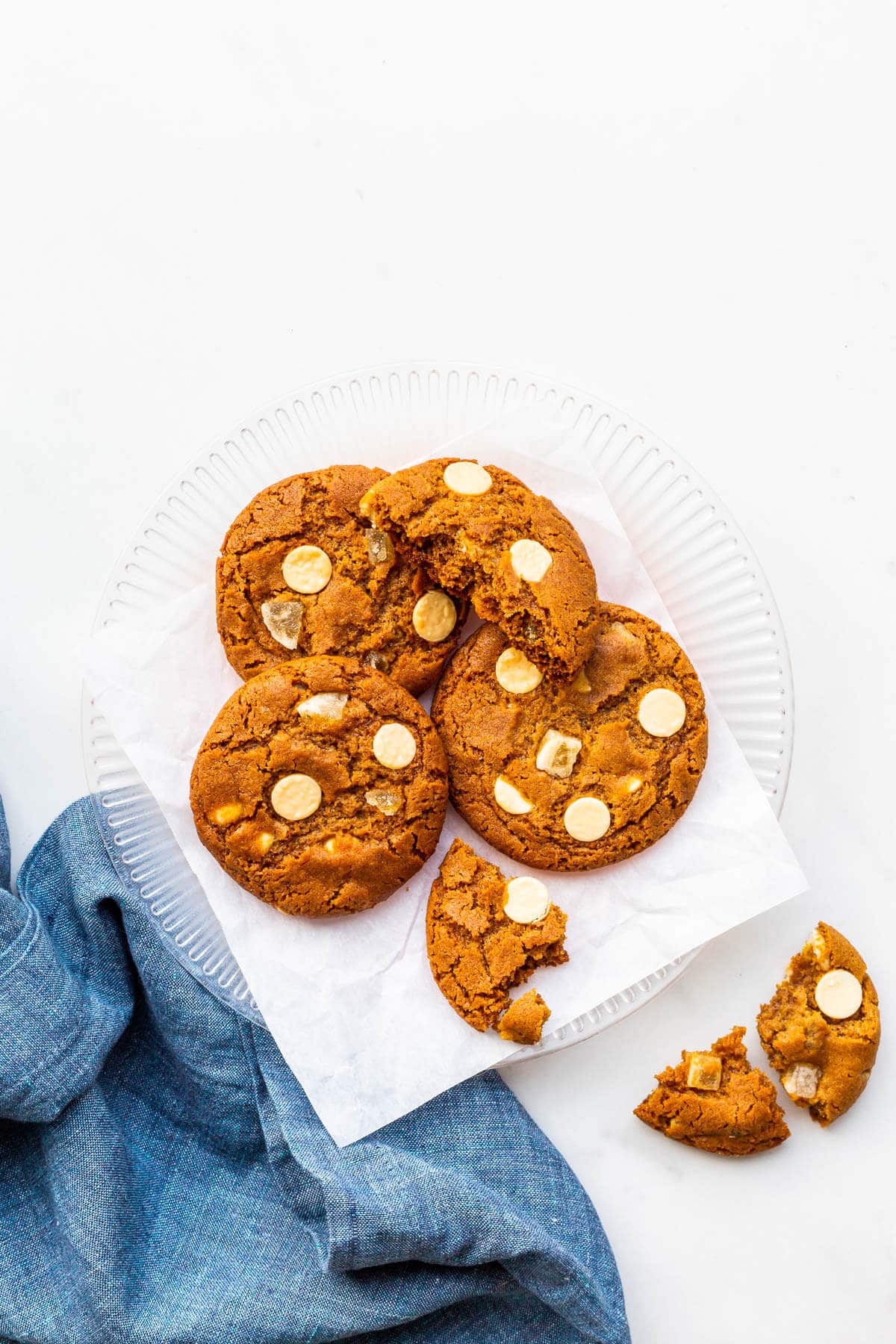 A plate of ginger cookies with white chocolate chips.