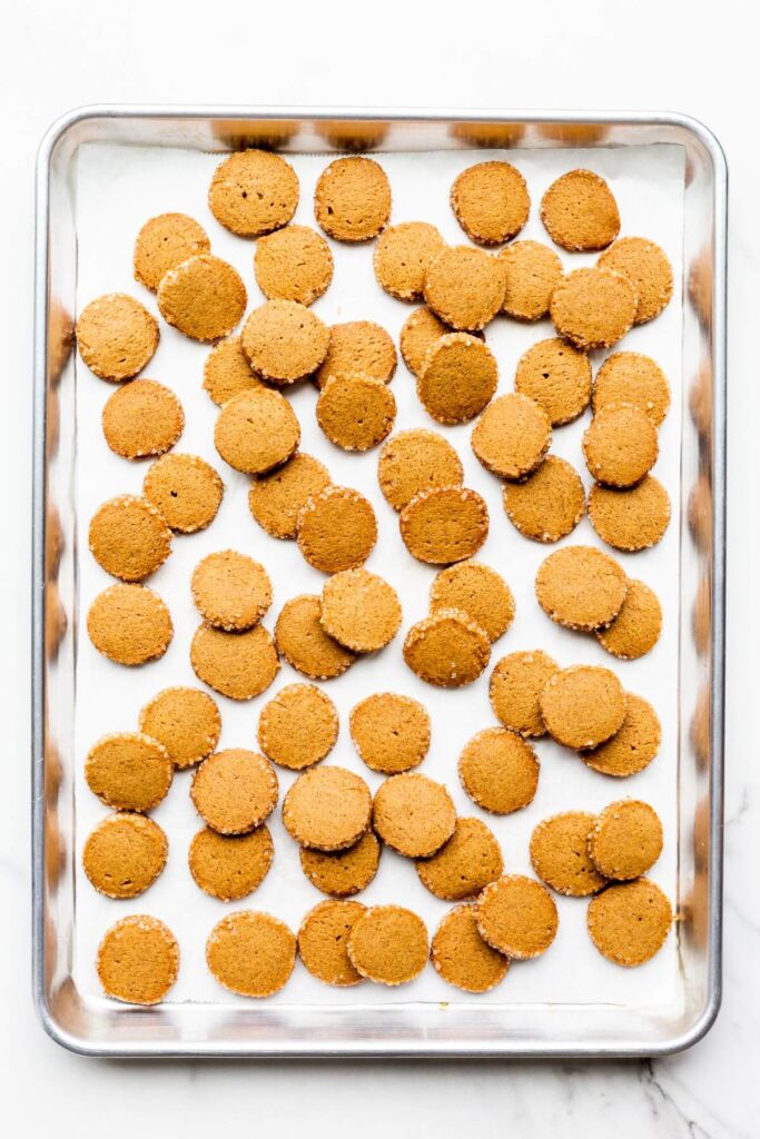 A sheet pan of gingerbread cookie coins with crunchy turbinado edges.