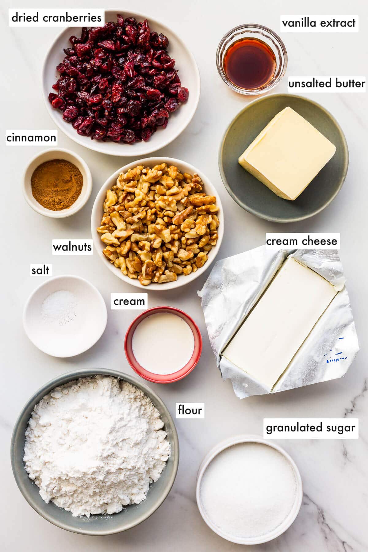 Ingredients to make rugelach with a cream cheese dough and filled with cinnamon, walnuts, and dried cranberries.