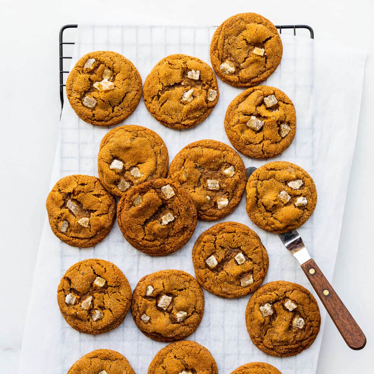 Freshly baked ginger cookies on a cooling rack.