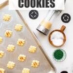 Using a cookie press to press out spritz cookies on an ungreased cookie sheet. The cookies are sprinkled with colourful sanding sugar before baking.