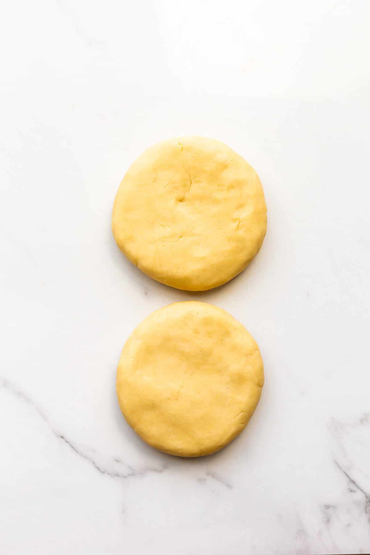 Sugar cookie dough divided into two equal disks.