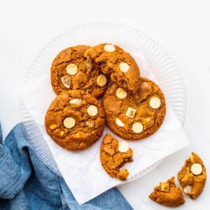 A plate of ginger cookies with white chocolate chips.