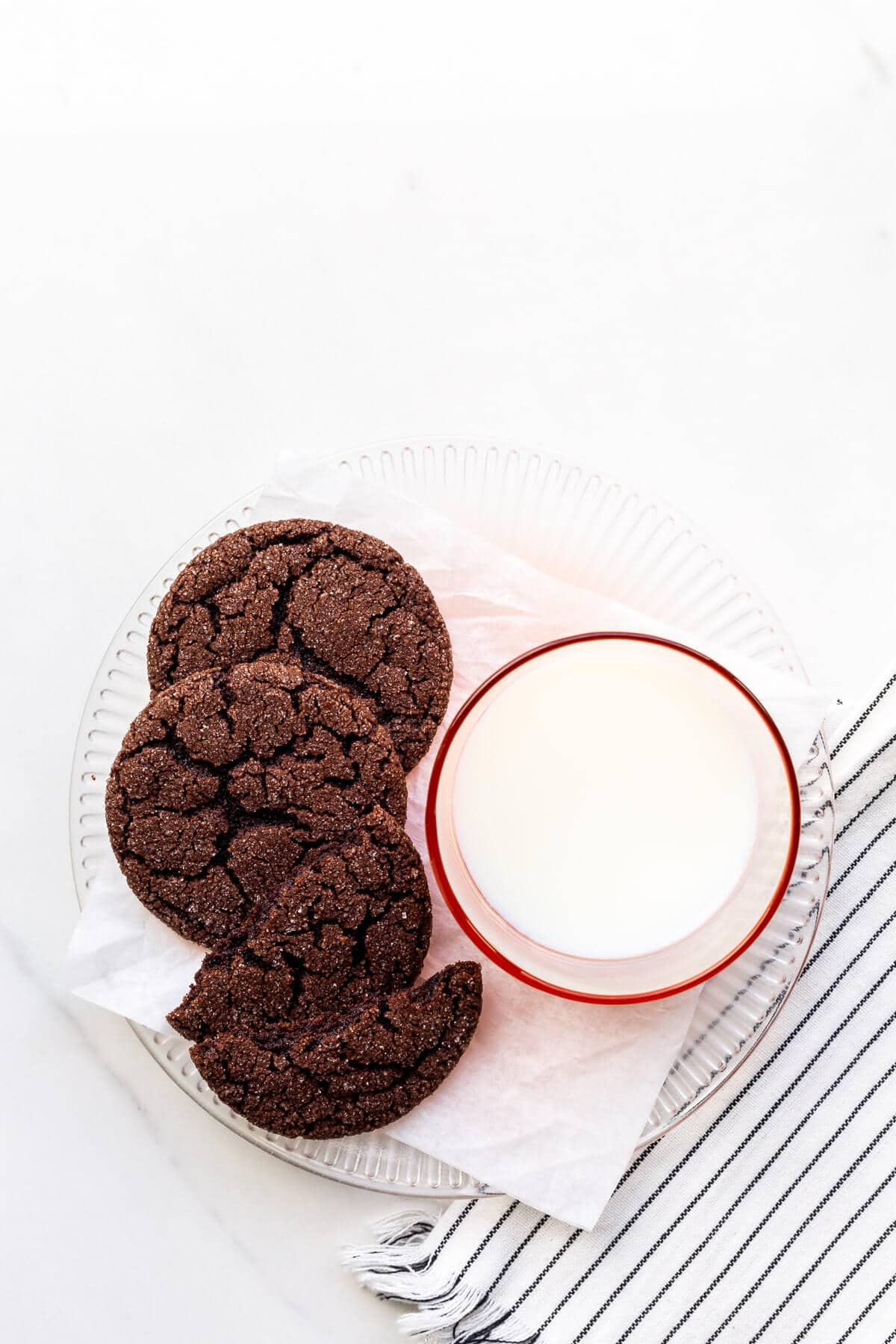 A plate of chocolate sugar cookies and a glass of milk.