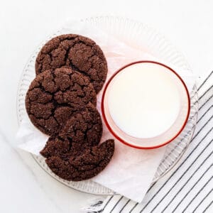 A plate of chocolate sugar cookies and a glass of milk.