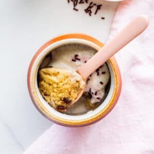 Chocolate chip mug cake cooked directly in a mug and served with ice cream and chocolate sprinkles.